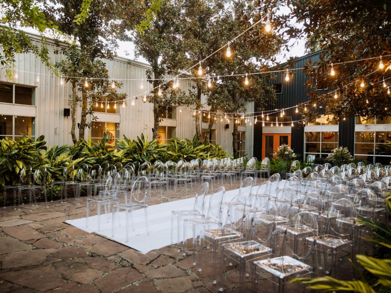 Decorated ceremonial area outdoors with modern transparent chair Decorated ceremonial area outdoors with modern transparent chairs and beautiful festoon with lots of trees and plants