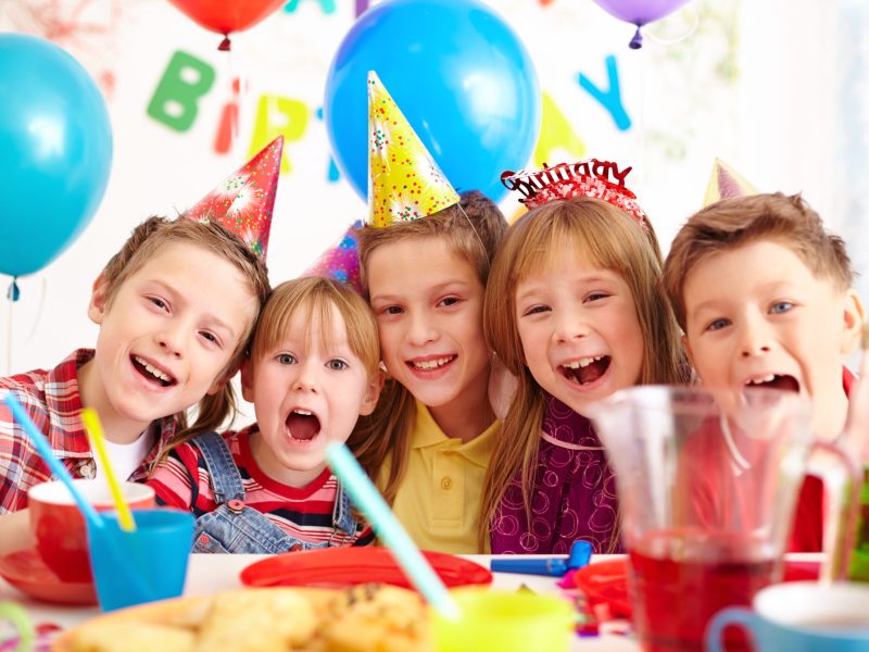 Group of adorable kids looking at camera at birthday party