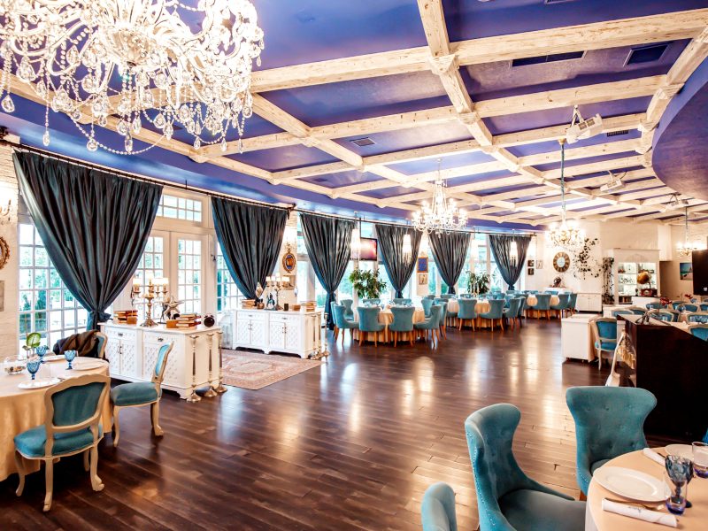 restaurant hall with turquoise chairs french windows navy coloured ceiling