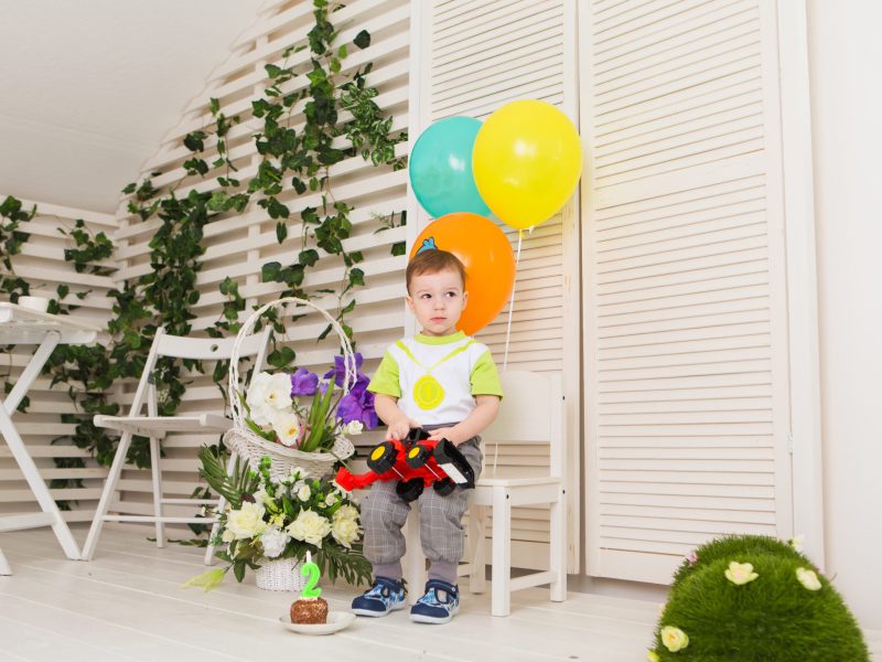 Child, birthday party and childhood concept - Little boy with a balloons indoors.
