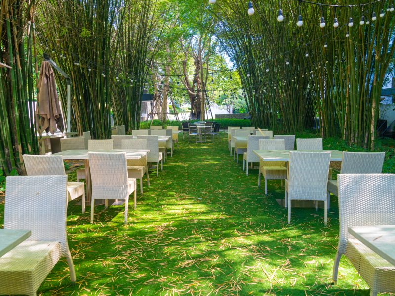 empty wicker table and chair in outdoor restaurant empty wicker table and chair in outdoor restaurant with bamboo forest garden