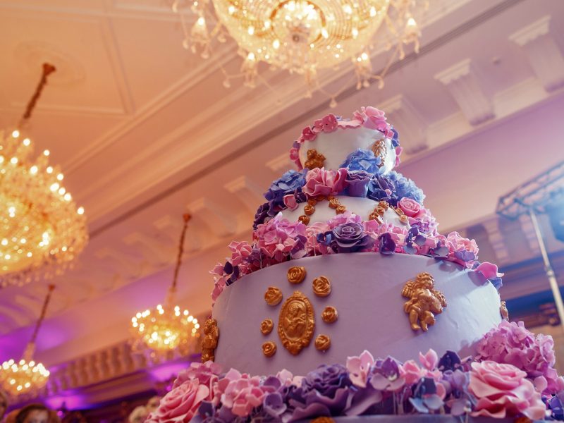 Magnificent violet wedding cake decorated with flowers and golden glaze